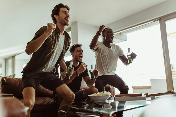 Friends celebrating a goal while watching a match together